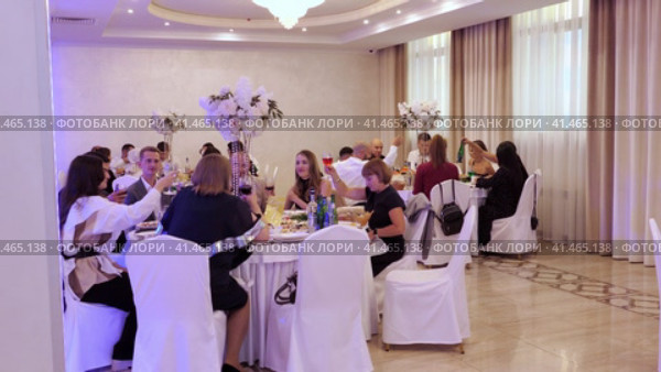 Nizhny Novgorod, Russia, Kazanskoye shosse 29, 08.31.2023. People at festive table with white tablecloths in restaurant eating delicious food. Нижний Новгород, Россия, Казанское шоссе, 29, 31.08.2023. Люди за праздничным столом с белыми скатертями в ресторане едят вкусную еду. Редакционное видео, видеограф Egor Sarantstv / Фотобанк Лори