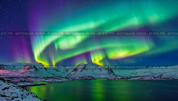 Northern Lights on the shore of a crystal lake and mountainous landscape. Colorful lights in the sky at low temperatures. Стоковое AI-изображение, AI-художник Антон Слабоспицкий / Фотобанк Лори