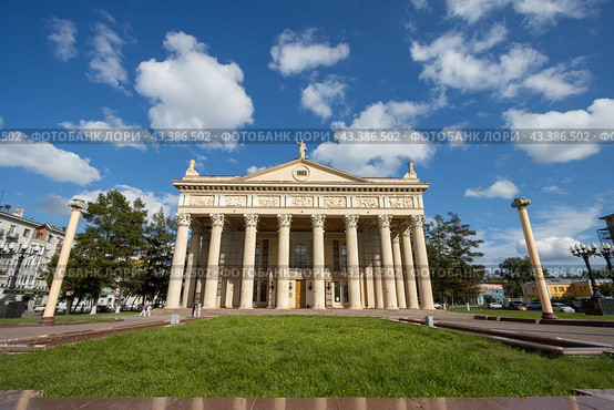 Новокузнецкий драматический театр, город Новокузнецк, Кемеровская область — Кузбасс, Россия. Вид с Театральной площади на красивое здание театра в неоклассическом стиле. Перед зданием установлены колонны. Архитектурная достопримечательность Новокузнецка. (2023 год). Редакционное фото, фотограф Андрей Степанов / Фотобанк Лори