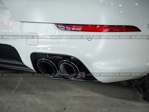 Novosibirsk, Russia -  July 14, 2025: Porsche Cayenne,  Close-up of dual chrome exhaust pipes. Редакционное фото, фотограф Виталий Сова / Фотобанк Лори