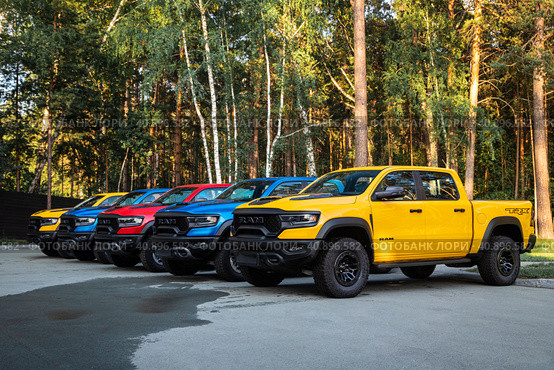 Novosibirsk, Russia - July 21, 2023: Row of multi-colored Dodge Ram Trx parked on the street on a warm summer day against the background of the park. Стоковое фото, фотограф Виталий Сова / Фотобанк Лори