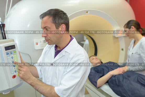 nurse and doctor as they prepare for an axial tomography. Стоковое фото, агентство Ingram Publishing / Фотобанк Лори