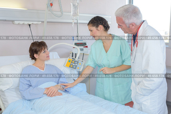 Nurse reassuring patient in hospital bed. Стоковое фото, агентство Ingram Publishing / Фотобанк Лори
