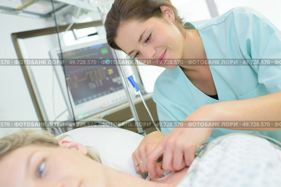 nurse tending to patients neck perfusion. Стоковое фото, агентство Ingram Publishing / Фотобанк Лори