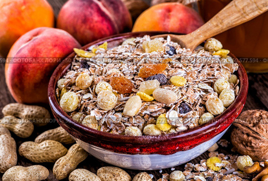 oatmeal in a sac, dried apricots, raisins, grapes, nuts on the background of wooden planks and sacking. Стоковое фото, агентство Ingram Publishing / Фотобанк Лори