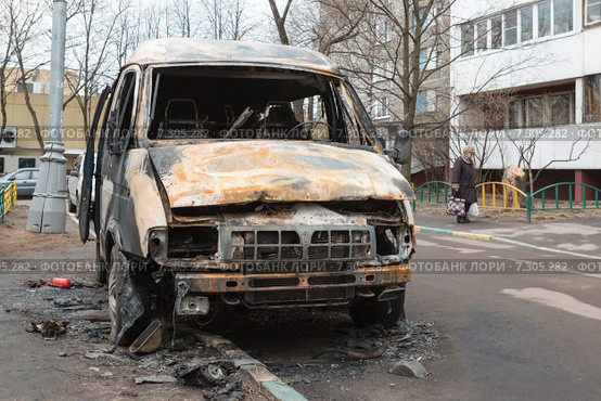 Обгоревший автомобиль ГАЗ "Соболь" в городском дворе (2015 год). Редакционное фото, фотограф Родион Власов / Фотобанк Лори