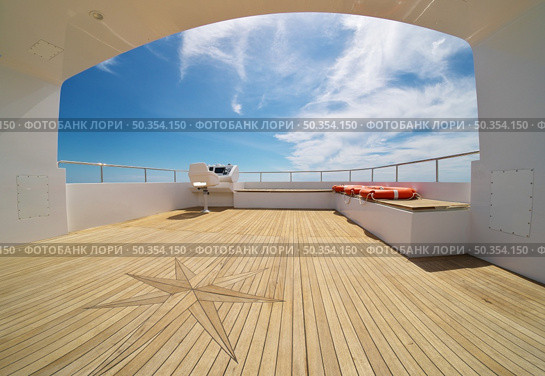Ocean calm water view from yacht flybridge open deck, modern and luxury equipped with navigation dashboard devices. Lifestyle freedom concept. Стоковое фото, агентство Ingram Publishing / Фотобанк Лори