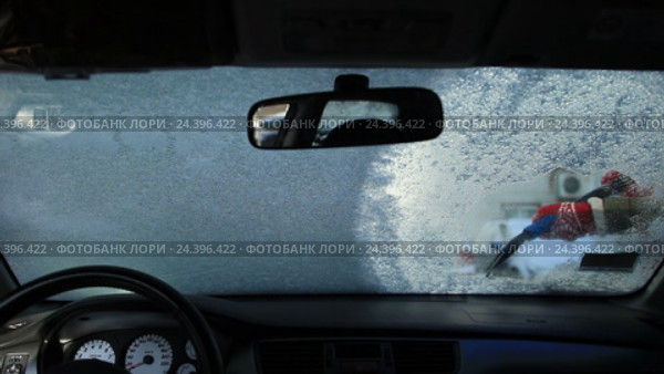 Очистка лобового стекла автомобиля от льда скребком. Стоковое видео, видеограф Швец Анастасия / Фотобанк Лори