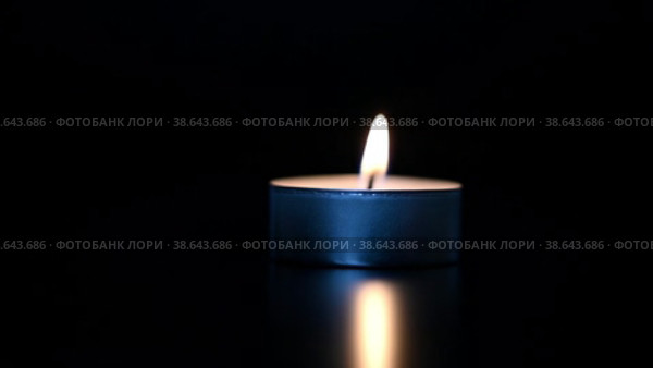 Одна белая свеча горит. Белая парафиновая свеча с желтыми оттенками горит на черном фоне. Стоковое видео, видеограф Васильева Юлия / Фотобанк Лори