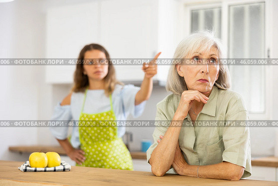 Offended senior woman at kitchen and listening daughter swearing. Стоковое фото, фотограф Яков Филимонов / Фотобанк Лори