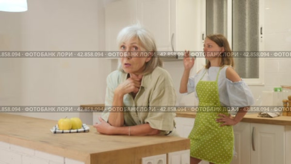 Offended senior woman at kitchen and listening her daughter swearing. Стоковое видео, видеограф Яков Филимонов / Фотобанк Лори