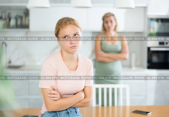 Offended teenage girl sitting in kitchen after disagreements with mother. Стоковое фото, фотограф Яков Филимонов / Фотобанк Лори