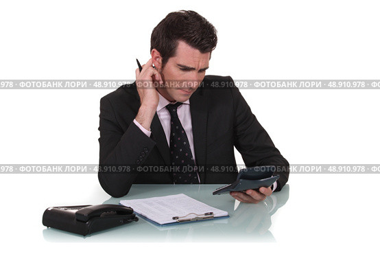 Office worker using calculator. Стоковое фото, агентство Ingram Publishing / Фотобанк Лори