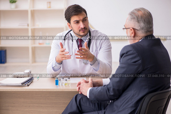 Old businessman visiting young male doctor in vaccination concep. Стоковое фото, фотограф Elnur / Фотобанк Лори