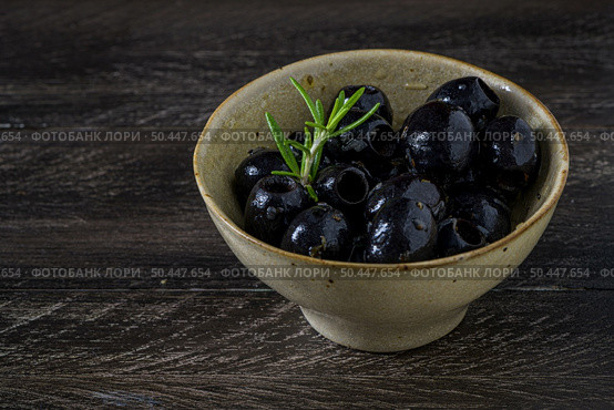 Olives in a ceramic bowl on a wooden table. Стоковое фото, агентство Ingram Publishing / Фотобанк Лори
