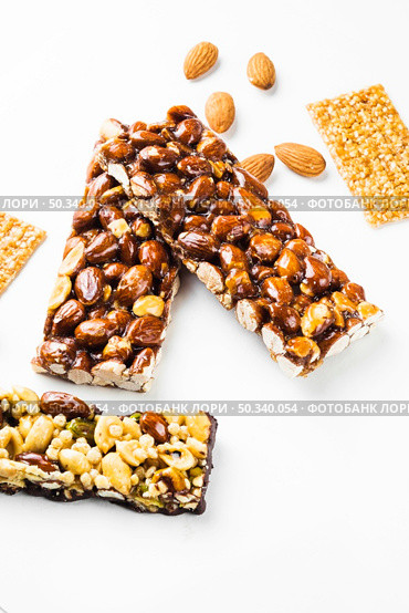OLYMPUS DIGITAL CAMERA. granola sesame seed almonds bars white background. Стоковое фото, агентство Ingram Publishing / Фотобанк Лори