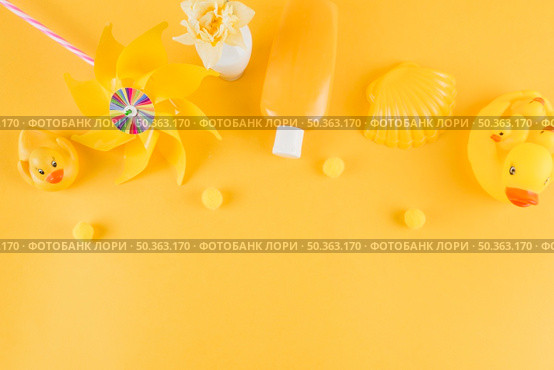 OLYMPUS DIGITAL CAMERA. rubber duck pinwheel sunscreen lotion bottle scallop with small pom pom yellow backdrop. Стоковое фото, агентство Ingram Publishing / Фотобанк Лори