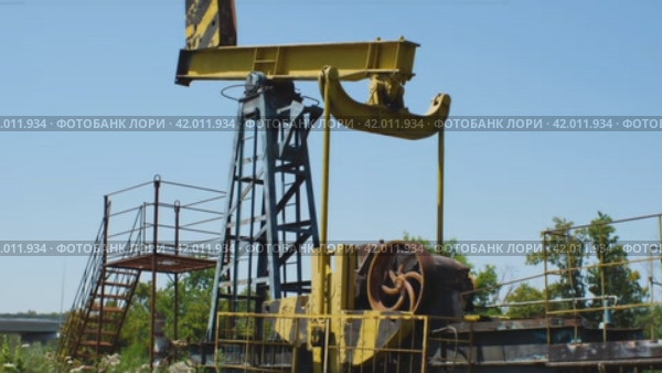Они выкачали всю нефть и оставили нефтяную вышку ржаветь в поле. Движение камеры снизу вверх. Концепция упадка нефтегазовой промышленности. Стоковое видео, видеограф Воловодов Владимир / Фотобанк Лори