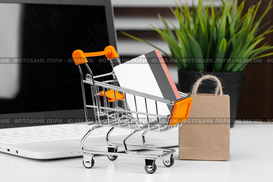 Online shopping concept. Shopping cart, laptop on the desk. Стоковое фото, фотограф Сергей Толмачёв / Фотобанк Лори