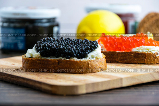 Open sandwiches with red and black caviar on a wooden board. Close-up shooting. Стоковое фото, фотограф Ярославский Максим / Фотобанк Лори