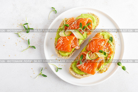 Open sandwiches with salted salmon, guacamole avocado and microgreens. Seafood. Healthy food. Top view. Стоковое фото, агентство Ingram Publishing / Фотобанк Лори