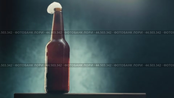 Opening a bottle of refreshing beverage in a dimly lit setting with atmospheric smoke. Стоковое видео, видеограф Сергей Толмачёв / Фотобанк Лори