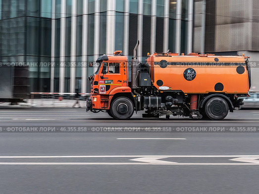 Orange street sweeper truck on city road in motion. Редакционное фото, фотограф Константин Григорьев / Фотобанк Лори