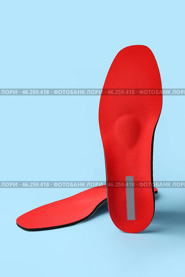 Orthopedic insoles on blue background. Стоковое фото, фотограф Pixel_shot / Фотобанк Лори