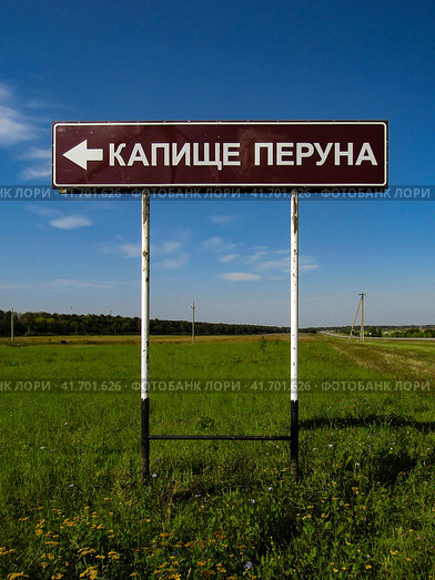 Oryol region, Russia - August 22, 2019. Road sign showing the way to a pagan temple in the name of Perun god. Дорожный указатель КАПИЩЕ ПЕРУНА, Орловская область. Стоковое фото, фотограф Александр Кузнецов / Фотобанк Лори