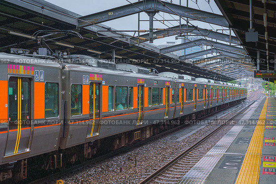 Osaka, Japan - Sep 22 2024, panoramic view of the railway station where the  electric train stands, there are no people on the platform, on a cloudy rainy day, Osaka, Japan. Стоковое фото, фотограф Сергей Богомяко / Фотобанк Лори