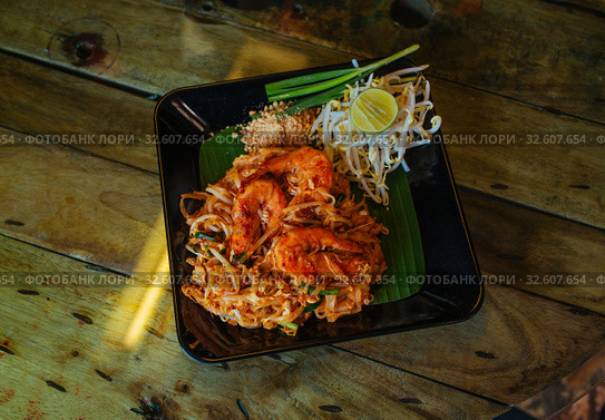 Pad Thai noodles with Seafood and nuts on the table. Стоковое фото, фотограф Aleksejs Bergmanis / Фотобанк Лори