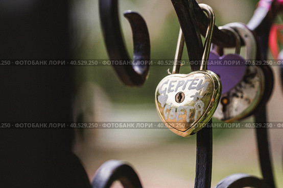 Padlock of lovers as a symbol of eternal love. Castles of love on the alley of love in Kolomenskoye Park. Стоковое фото, фотограф Photojuli / Фотобанк Лори