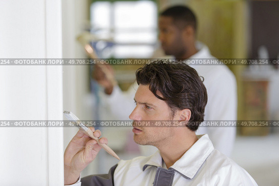 painter using a brush to finish a white wall. Стоковое фото, агентство Ingram Publishing / Фотобанк Лори