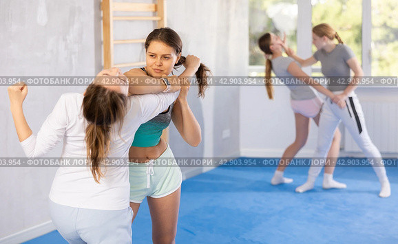 Pair self defense training - two teenage girls doing power grabs. Стоковое фото, фотограф Яков Филимонов / Фотобанк Лори