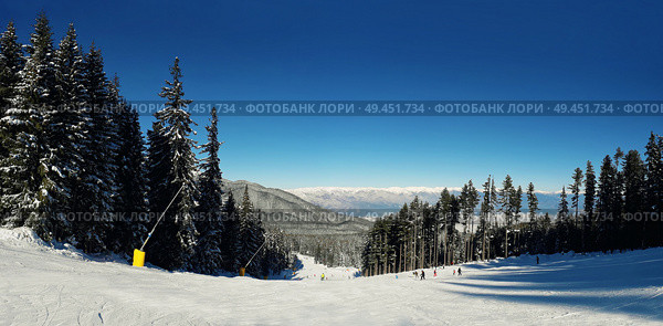 Panorama of snowy mountains in the winter season. Landscape ski trails with a blue sky on a clear day. Pirin peaks picturesque view of glaciers and rocky slopes. . Стоковое фото, агентство Ingram Publishing / Фотобанк Лори