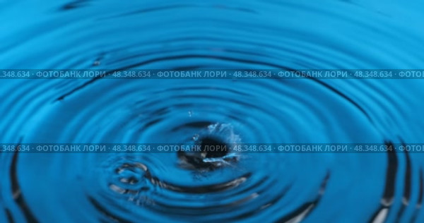 Панорама падения капель воды в голубую воду. Красивая круговая волна, рябь. Капля воды, падающая на поверхность воды. Стоковое видео, видеограф Александр Собко / Фотобанк Лори