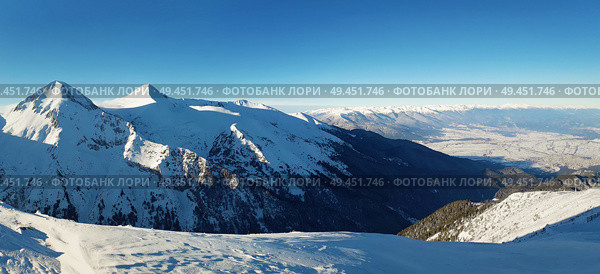 Panoramic view from the top of Pirin mountains to the ridge peaks. Cold snowy winter day and clear blue sky. Стоковое фото, агентство Ingram Publishing / Фотобанк Лори