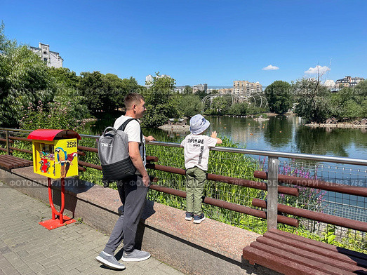Папа с ребенком наблюдают за птицами на Большом Пресненском пруде в Московском зоопарке летом. Россия, Москва. Редакционное фото, фотограф Овчинникова Ирина / Фотобанк Лори