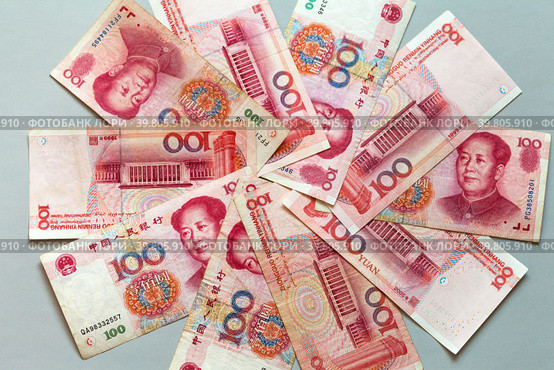 Paper money in denominations of 100 yuan are laid out in a circle on a light table. Chinese economy and finance. Currency background. The concept of finance, banking, investment, business and lending. Стоковое фото, фотограф Виктория Катьянова / Фотобанк Лори