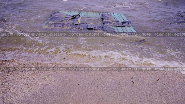 Part of wall of house floats near shore, floating debris has reached Black Sea beaches in Odessa, Ukraine. Environmental disaster caused by explosion of Kakhovka Hydroelectric Power Plant dam, closeup. Стоковое фото, фотограф Некрасов Андрей / Фотобанк Лори