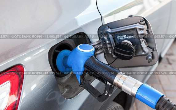 Passenger car is refueled at a gas station. Gasoline pump gun to release fuel. Стоковое фото, фотограф FotograFF / Фотобанк Лори