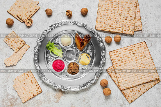 Passover Seder plate with traditional food, walnuts and matza on light background. Стоковое фото, фотограф Pixel_shot / Фотобанк Лори