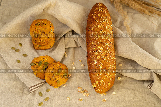 Печенье круглое домашнее злаковое постное, багет зерновой на кухонном льняном полотенце. Стоковое фото, фотограф Оксана Шведкова / Фотобанк Лори