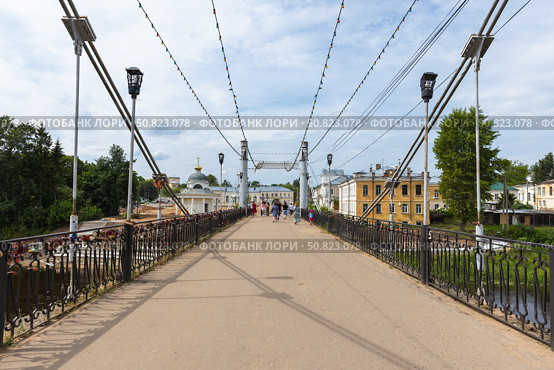People walk the Pedestrian bridge over Tvertsa river on a sunny day. Редакционное фото, фотограф EugeneSergeev / Фотобанк Лори