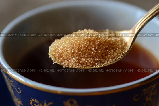 Person adding cane sugar with a spoon to cup of fresh aromatic coffee. Close up of teaspoon putting brown sugar into hot steamed drink mug. Sugar Being Poured into Cup of Coffee Americano, Close-Up. Стоковое AI-изображение, AI-художник Марина Демидюк / Фотобанк Лори