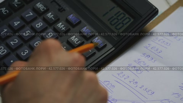 Person Calculating Budget on Electronic Calculator With Handwritten Notes in Office Environment. Стоковое видео, видеограф Сергей Толмачёв / Фотобанк Лори