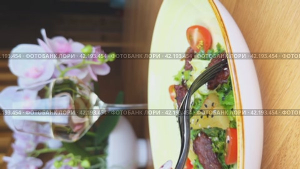 Person pricks a peace of beef on a fork. Eating warm salad. Vertical video. Close-up. Concept of Healthy Lifestyle and Healthy Nutrition. Стоковое видео, видеограф Сахарова Мария Юрьевна / Фотобанк Лори