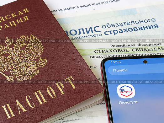 Персональные данные гражданина РФ: паспорт, медицинский полис, СНИЛС и телефон с электронным приложением Государственные слуги (2023 год). Редакционное фото, фотограф Татьяна Т / Фотобанк Лори