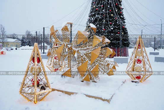 Petrozavodsk, Russia, January 10 2024: Small architectural forms in the form of luminous cones and a large cone, made of garlands and light bulbs. Festive decoration of city streets and squares. Xmas. Редакционное фото, фотограф Юлия Петровская / Фотобанк Лори