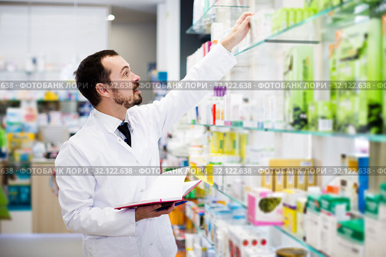 Pharmacist writing down assortment of drugs. Стоковое фото, фотограф Яков Филимонов / Фотобанк Лори